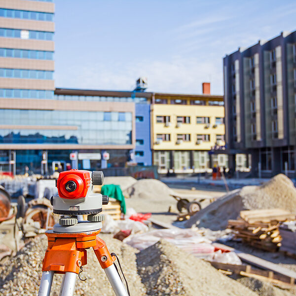 Surveying measuring equipment level transit on tripod at construction building area site